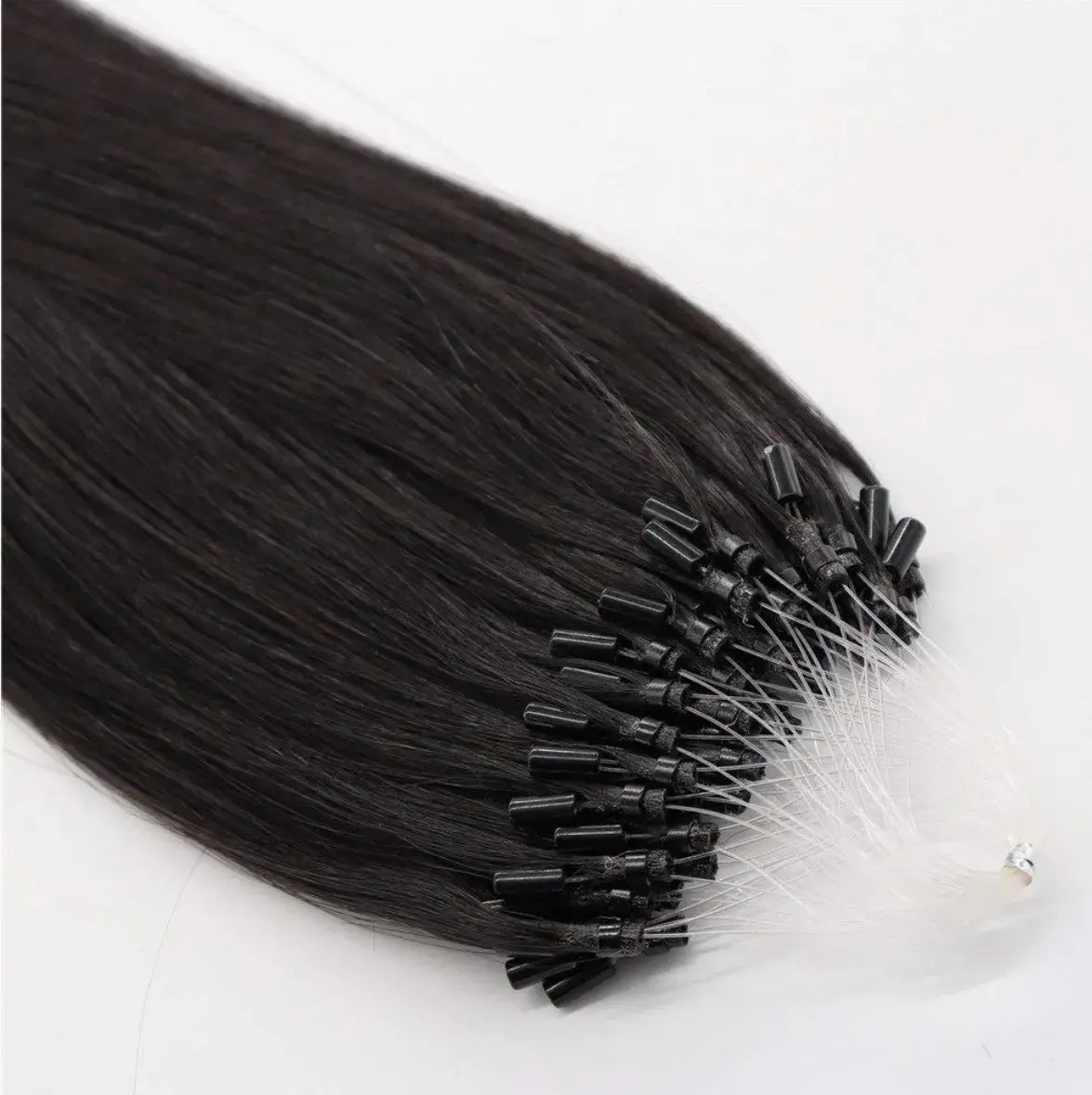 Close-up of black seamless micro-link extensions by Hypnotic Virgin, showing fine attachment tips for a discreet, natural hair blend.